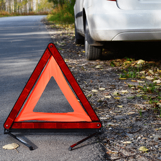 A yield sign behind a broken down car