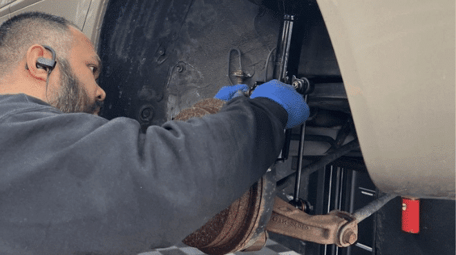 An auto technicians doing suspension services on a car at EG Auto Center in Dayton, NJ.