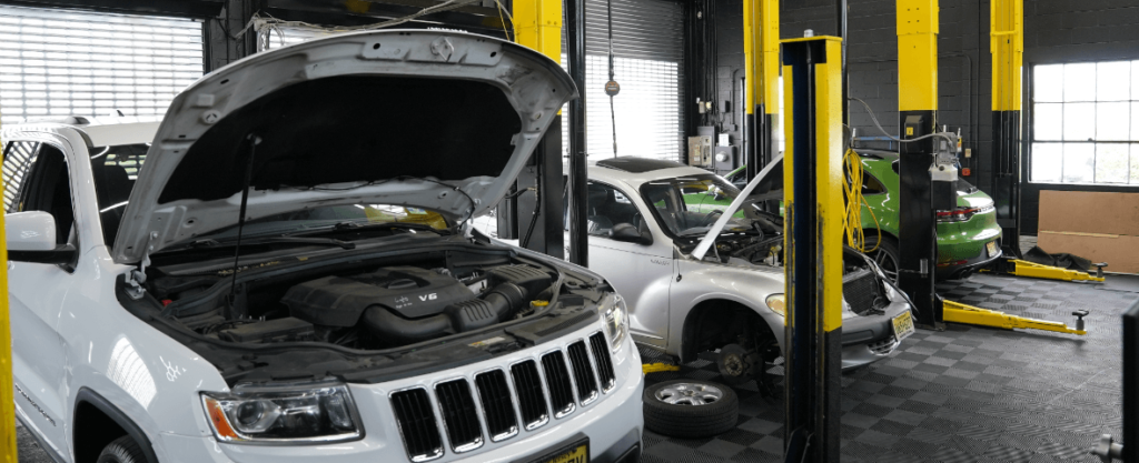 Three cars inside the auto repair shop at EG Auto Center in Dayton, NJ