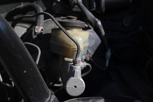 Brake Master Cylinder Replacement by EG Auto Center in Dayton, NJ. Closeup image of a brake master cylinder in a car.