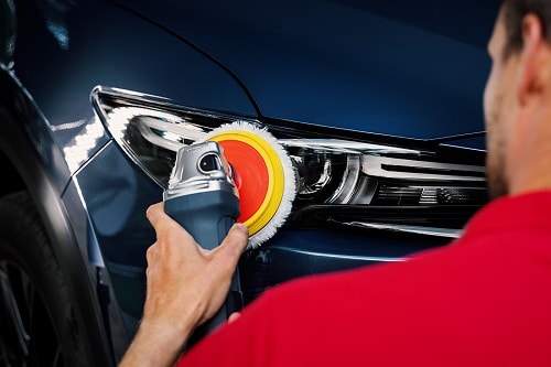 Headlight Restoration | EG Auto Center in Dayton, NJ. Image of a man polishing car headlight with polish machine to restore vehicle headlights.