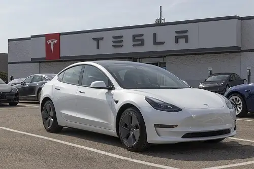 EV and Hybrid Repair and Maintenance in Dayton, NJ | EG Auto Center in Dayton, NJ. Image of a white Tesla electric car on display in front of a Tesla facility.
